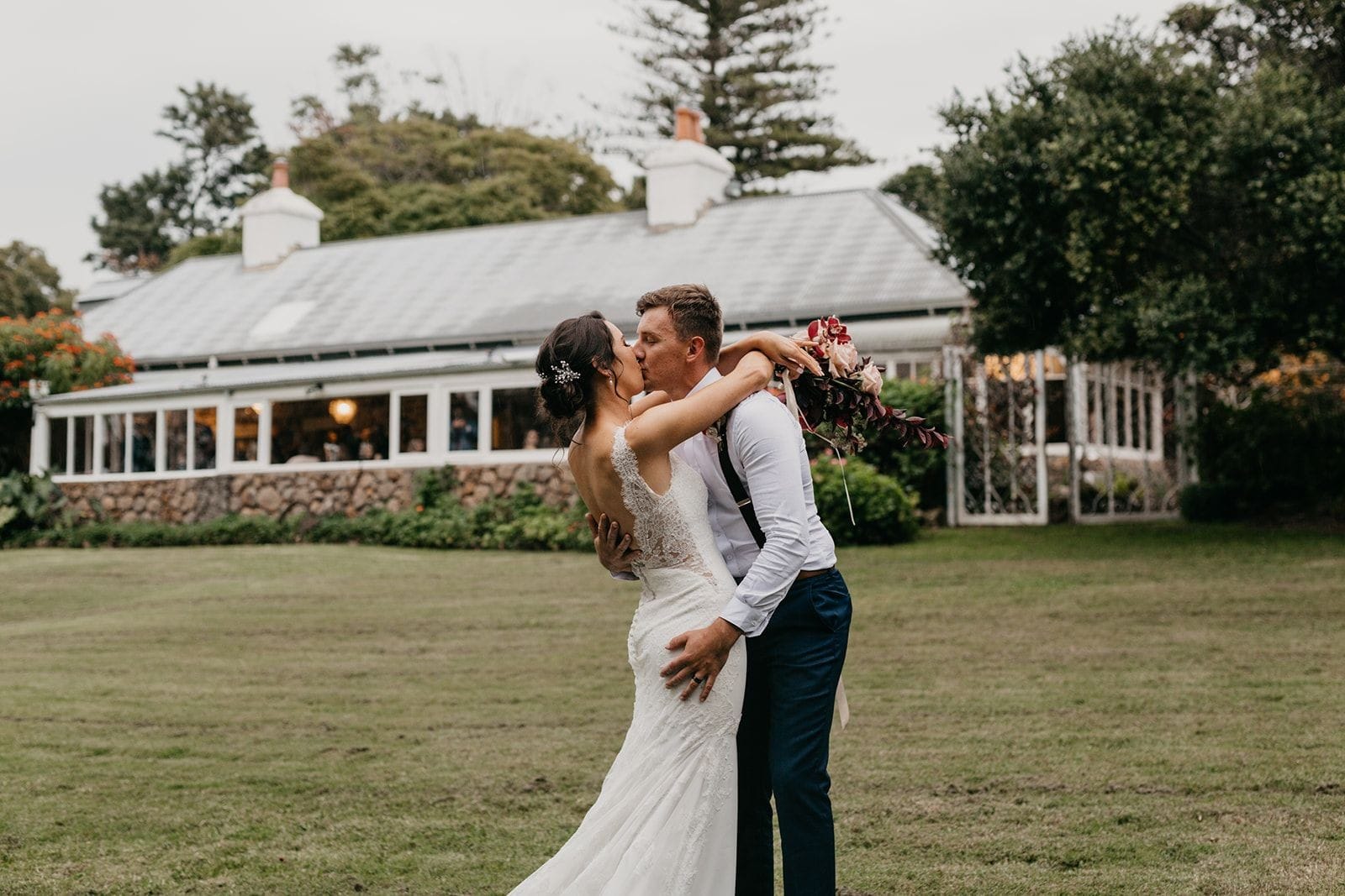 Garden wedding shot of couple overlooking garden, iron gates and Tanilba House