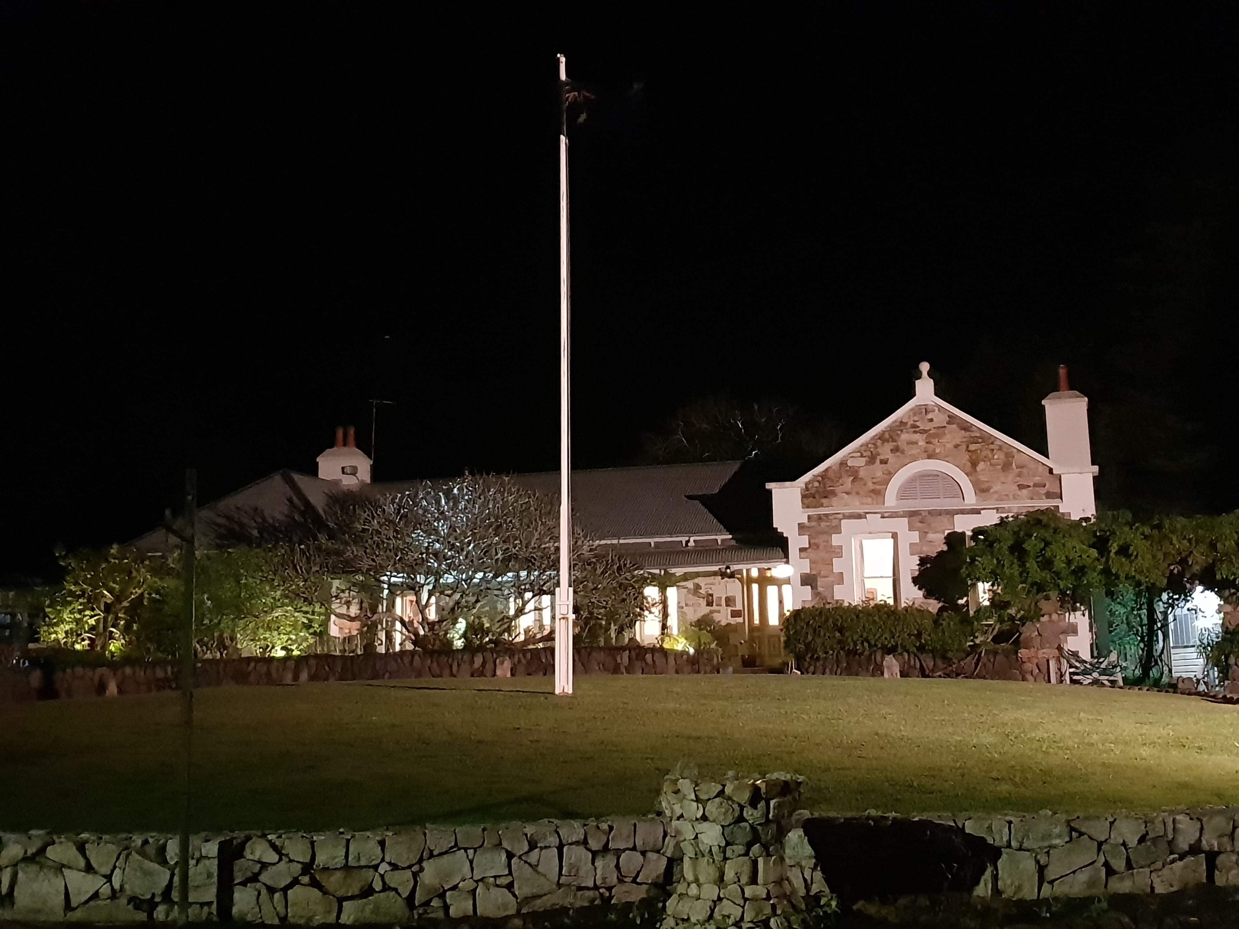 Tanilba House Port Stephens lit up at night. Front of house with front stone driveway