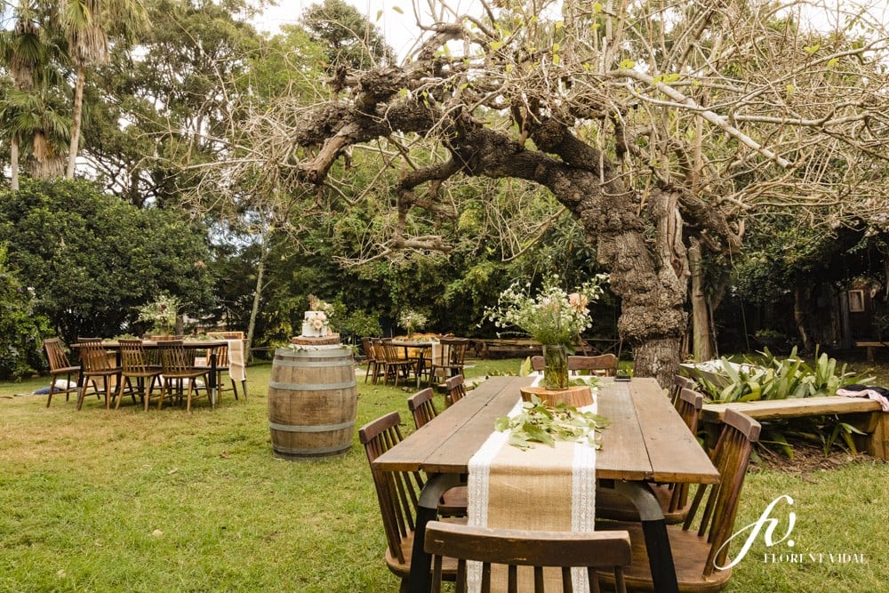 Rustic set up of tables, wine barrels and florals for relaxed garden party wedding