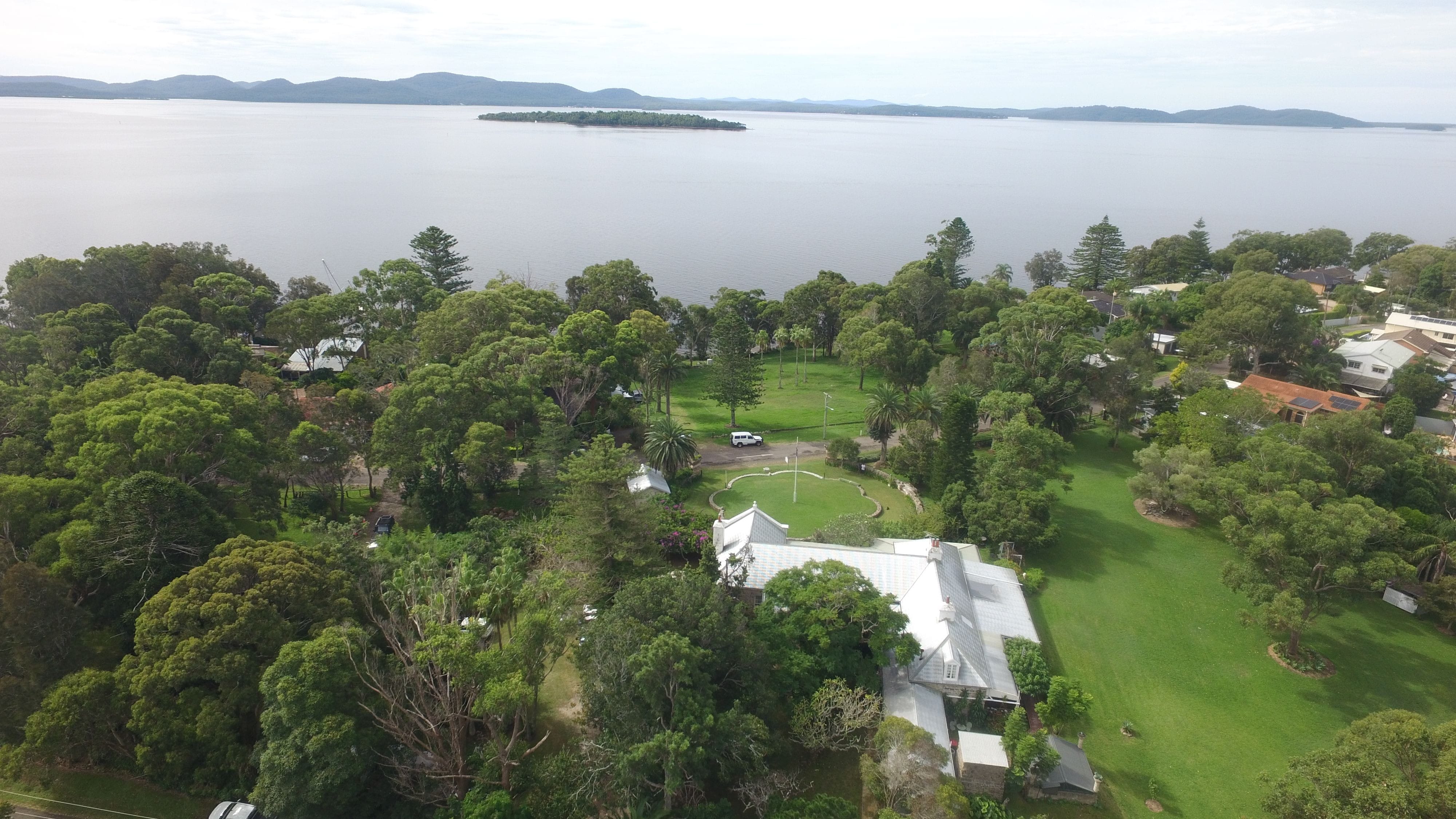 Drone shot of Tanilba House 3 acres of garden and tree aspect overlooking the waterfront  over Meridian Park